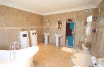 with mixer tap set in vanity unit with cupboards beneath Tiling to floor, half-tiled walls with feature border tile Range of fitted furniture including wardrobes and cupboards Utility Room 399m x