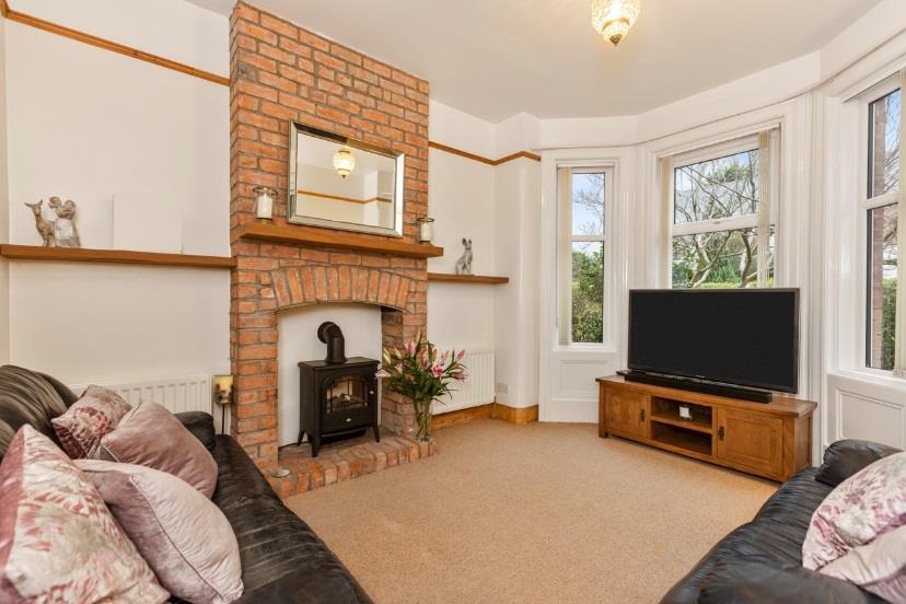 Downstairs comprises, entrance hall, a spacious living room with feature fireplace and a bay window, a separate sitting/dining room with a multi fuel stove and patio doors to the rear, a modern