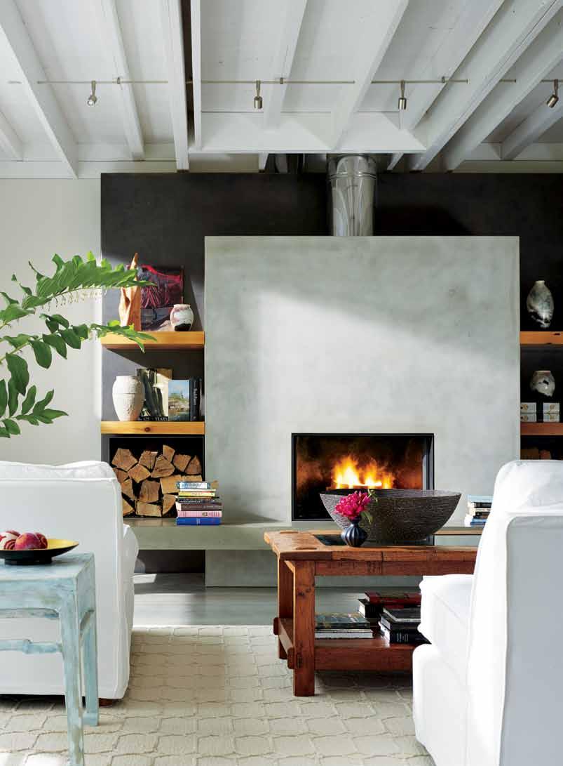 Floating shelves made from salvaged wood and a farmhouse-style coffee table add softness to the room.