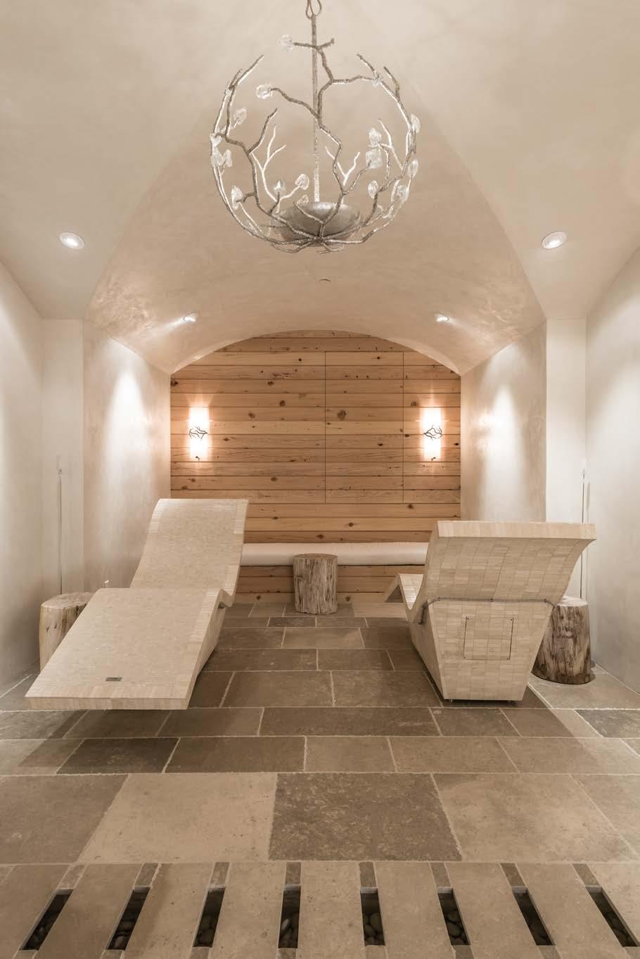 LEFT: A serene spa with vaulted ceiling features tiled heated loungers, a waterfall feature that runs along a trough under the floor and an ethereal