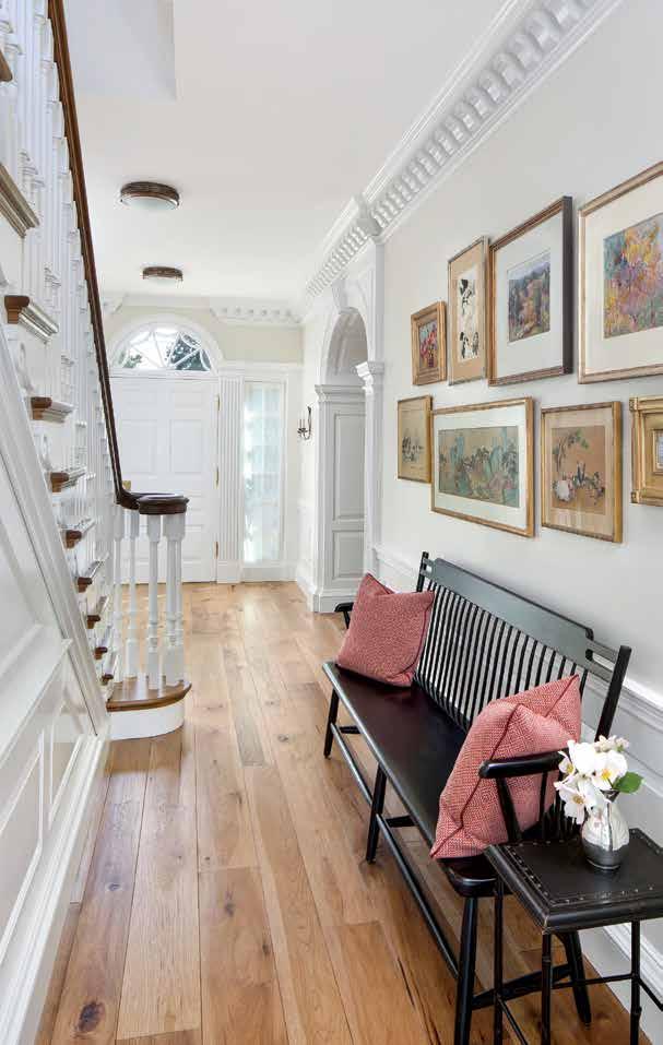 Right: Artwork collected by the homeowners hangs in a curated grouping along the wall of the entry hallway.