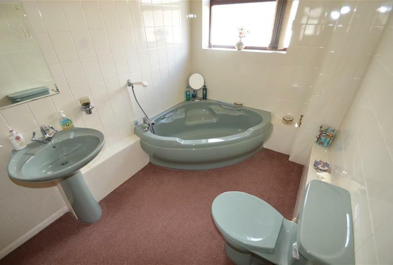 C With modern suite comprising large walk-in shower cubicle with shower attachment and glass screen above, modern wash hand basin with mixer taps and with storage beneath and mirror fronted medicine