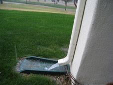 A splash block placed beneath the downspout elbow