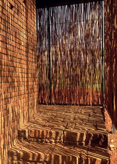 Horizontal bands of red brick act as a counterpoint to the vertical organic waves of the eucalyptus screens;