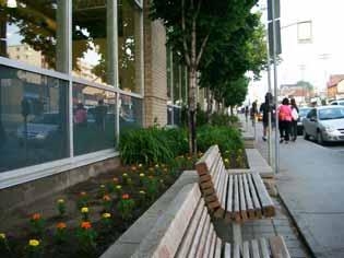 Guideline 38: Landscape any area between the building and the sidewalk with foundation planting, trees, street furniture and walkways to the public sidewalk (Figures 22 and 23).