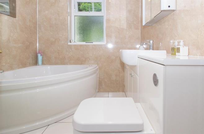 11m (6' 11") UPVC window to the rear, marble effect cladding to the walls, stainless steel towel rail, tiled floor, white suite comprising of Spa corner bath, separate enclosed shower unit with mixer