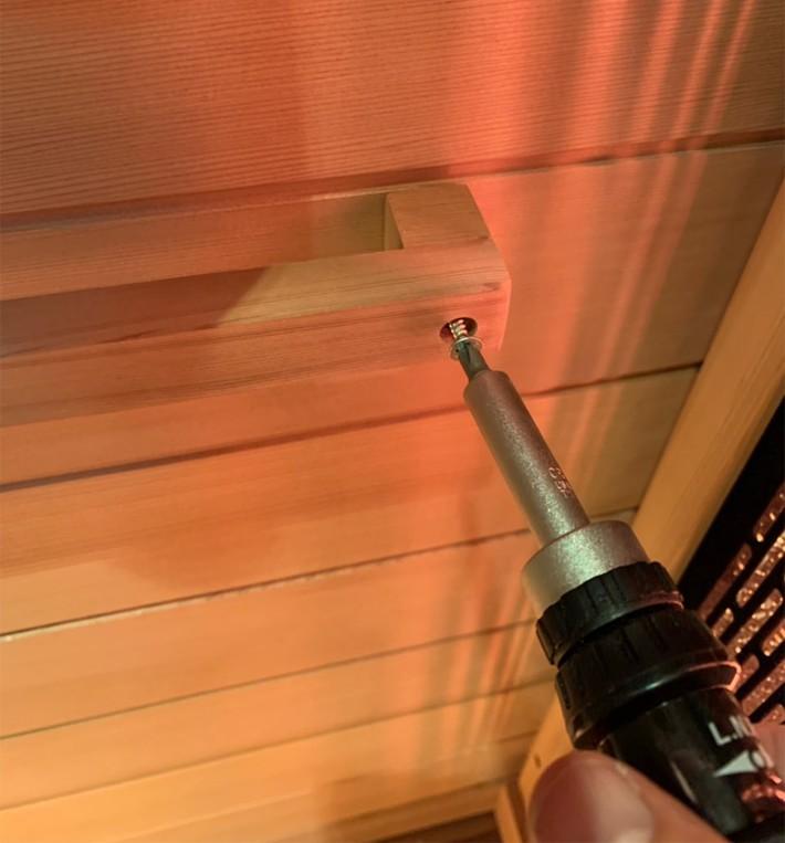 attach to sauna wall with screws (this will be permanent so be careful and
