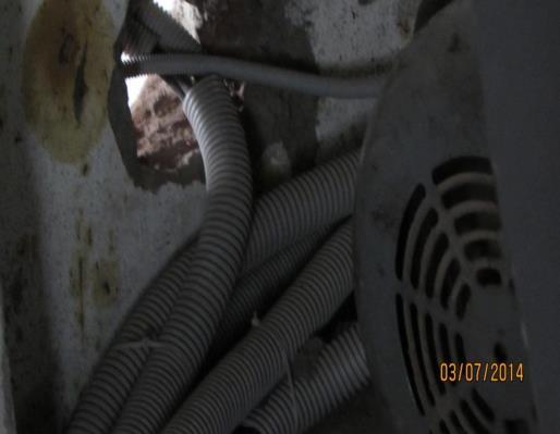 E- 31 Cables encased in flexible pipes passing through wall not protected and remaining gaps not sealed.