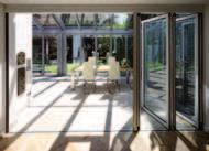 Folding glass doors form a partition between the living space and the wintergarden, and