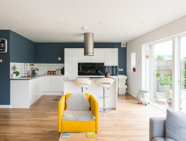 KITCHEN Simple white gloss cabinets and an island unit have been positioned to enjoy views out across the garden.