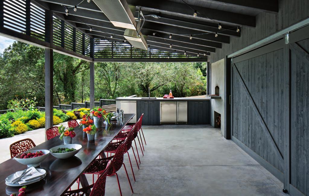 The outdoor dining table from Shed is lined with Caprice chairs from Room & Board sporting red nylon seats.