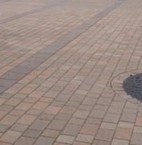 It is industry standard that bits of aggregate can show on the surface of the paver and the darker aggregate
