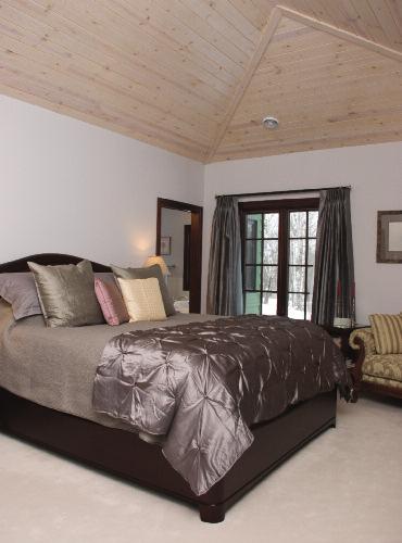 Left: A vaulted ceiling in the master suite done in white-washed pine helps create the room s comfortable ambiance.