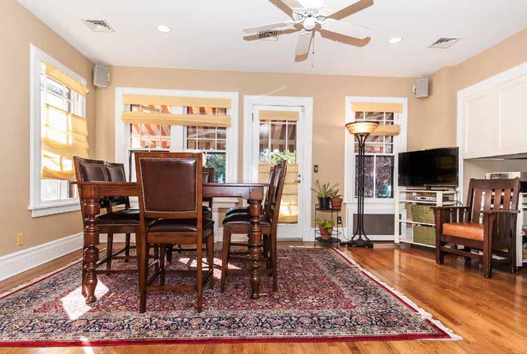 New Family Room/Breakfast Area with new wide-plank hardwood floor, recessed lighting and ceiling fan exposed original stone and brick wall, built-in bookcase and built-in entertainment center with