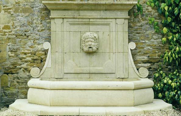 The Neptune Wall Fountain [item 8] A large hand carved natural limestone wall fountain having an elegant carved wall plate with