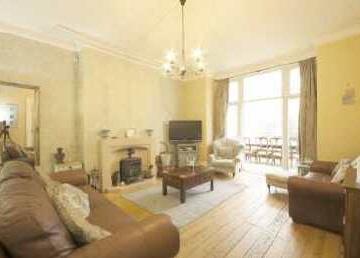 52m) Detailed cornice ceiling, central plaster rose, stone fireplace with log burner on hearth, exposed wood flooring, radiator, UPVC, double doors opening into;