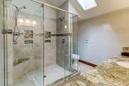 decorative mirrors, (2) light fixtures above vanity, large walk-in shower with