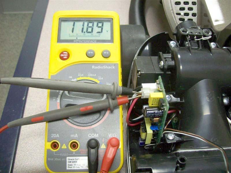 c. With the Red meter probe in contact with the Red conductor of the connector and the Black probe in contact with the White conductor, plug in the power cord: 12VDC should be present as shown (11.