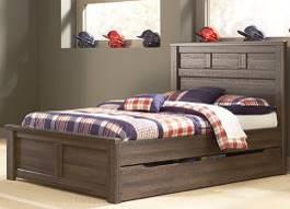 casual group in an aged brown rough sawn finish over replicated oak grain that gives it a reclaimed wood look Substantial sized warm pewter color drawer handles King and queen beds also available