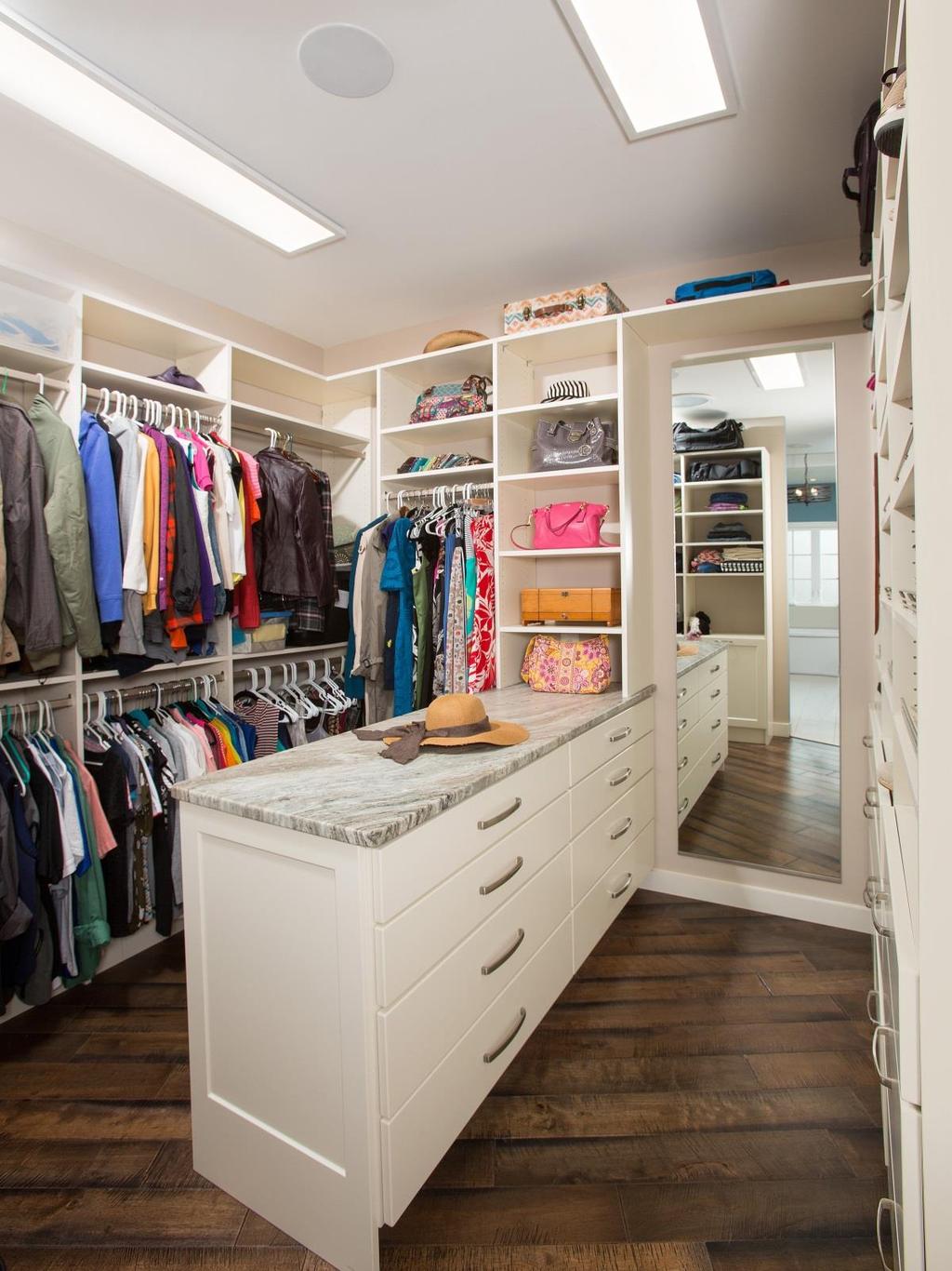 An organized his and her master closet was essential for our clients. The shelves along the perimeter and the drawers on the center were custombuilt.