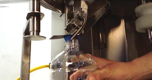 If cap does not gently come to rest directly on top of the bottle, reach up behind capsetter and release the red-handled toggle clamp with one hand.