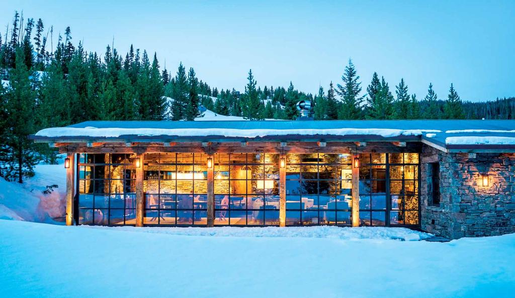 An expanse of steel-framed, triple-paned windows seems to float free of the stone walls on either side, heightening the illusion that the recently built cabin was salvaged from an historical relic