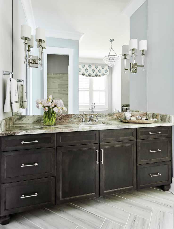 His-and-her vanities sit atop herringbone-patterned tile that creates visual interest, and