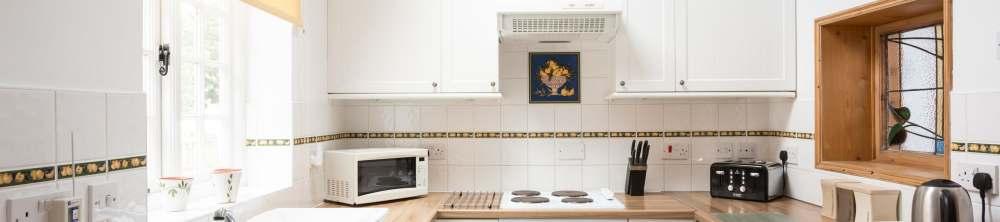 Four ring electric hob with extractor hood over and electric oven. Automatic washing machine point.