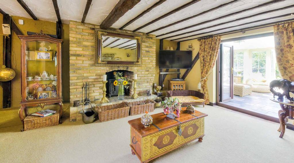 SITTING ROOM 5.50m x 4.35m Double glazed leaded light window to side aspect. High ceiling. Exposed beams to walls and ceiling. Inglenook fireplace with brick hearth and inset wood burning stove.