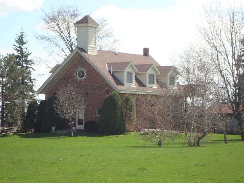 L 1-13 Figure 9: Northwest elevation of Castlemore Schoolhouse showing gable roof, bell tower, bullseye window and dichrome brick