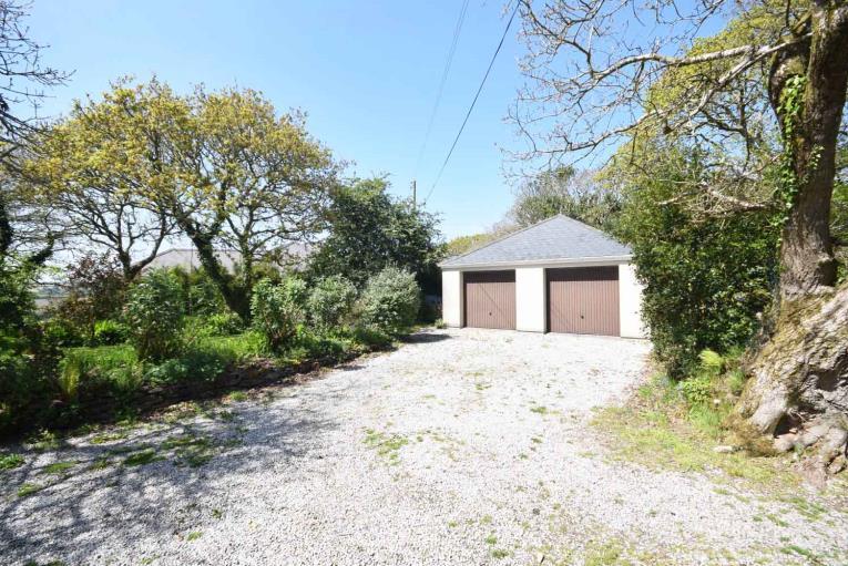 6 OUTSIDE From the driveway, gated access is giving to a large gravelled parking area for numerous vehicles and:- LARGE DETACHED DOUBLE GARAGE.