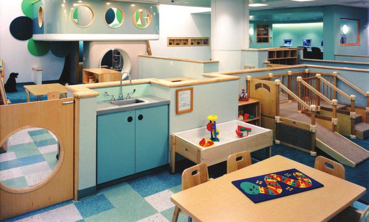 The open plan classroom is divided up into areas for children of different age groups.
