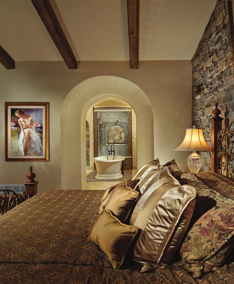 TOP RIGHT: The exterior stone is used on an accent wall in the master bedroom, much like a typical Tuscan home. The heavy, aged beams appear throughout the house to create continuity.