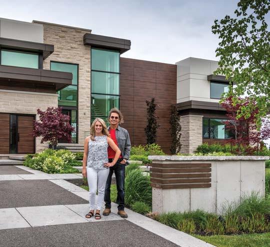 LEFT: With smiles on their faces, Dave and Christine Harrington of Absolute Craftsmen stand proudly in front of this spectacular waterfront home.