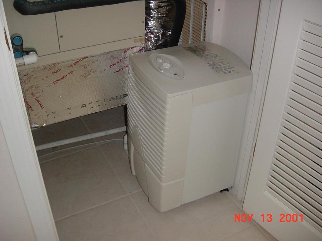 Dehumidifier and ventilation duct in interior mechanical closet with louvered door