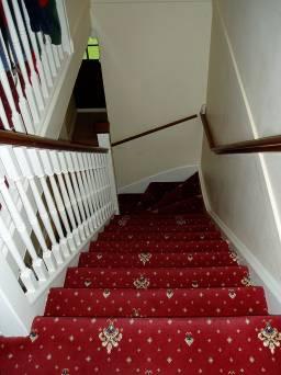 STAIRCASE White painted wooden staircase, spindles, stained wooden handrail, banister and