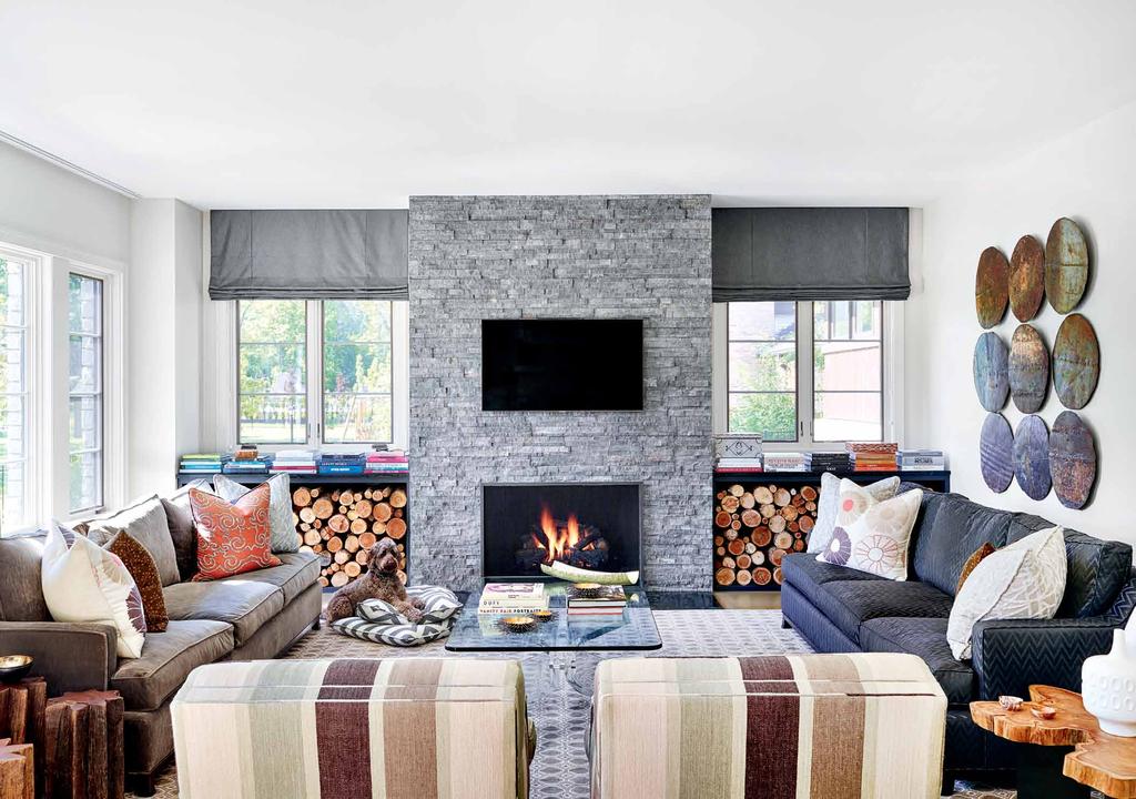 The welcoming family room of this North Shore home designed by Michelle Williams invites lounging on custom Barclay Butera sofas, which are covered in dark gray Brentano and light gray Pollack