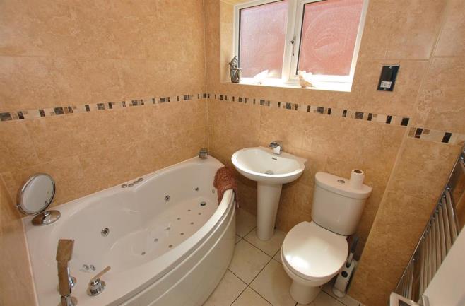 BATHROOM With a door leading from the landing this modern fitted bathroom his a jacuzzi bath with shower attachment, WC, wash hand basin, fully tiled walls, tiled flooring, recessed spotlights,