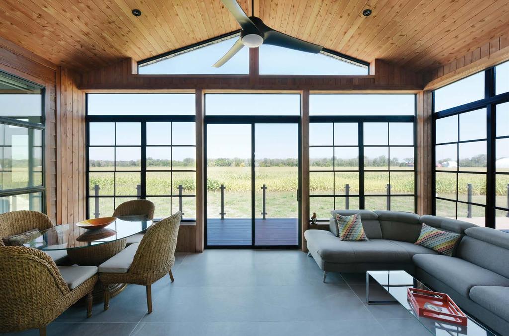 With its high-pitched ceiling, the sunroom features a wall of windows on three sides and provides access to the back deck, along with a view of the cornfields on the