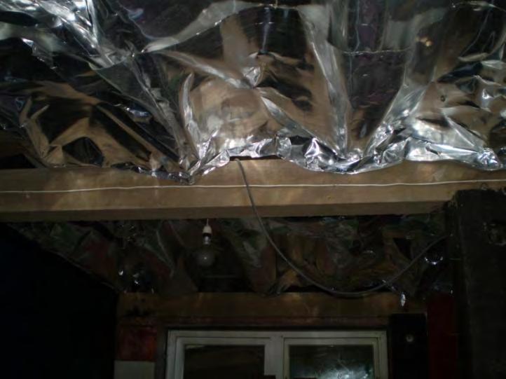 Photo of the foil layer directly below the master bedroom. The installed foil is not effective and needs to be replaced. The foil should be fit flat across the floor joists with no draping. 2.