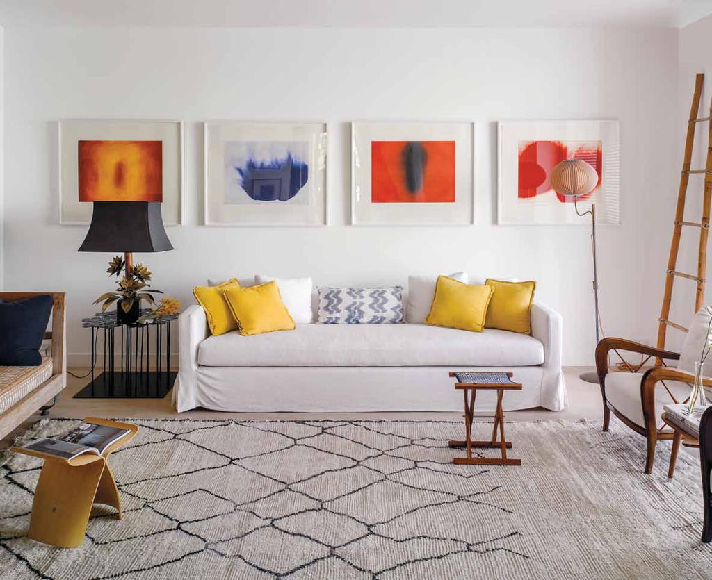 Four vibrant Anish Kapoor paintings, two vintage armchairs, lamps bought in flea markets in Paris, a wool Berber rug from Morocco, a Sori Yanagi butterfly