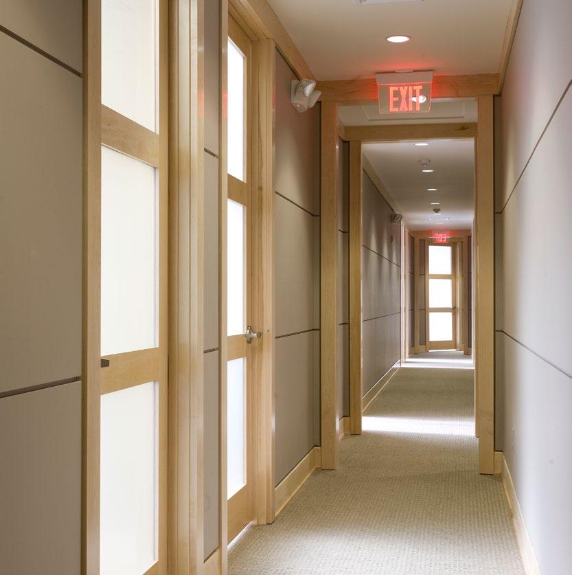 connected Executive Suites New Construction Translucent glass paneled doors, pale wood and recessed lighting give