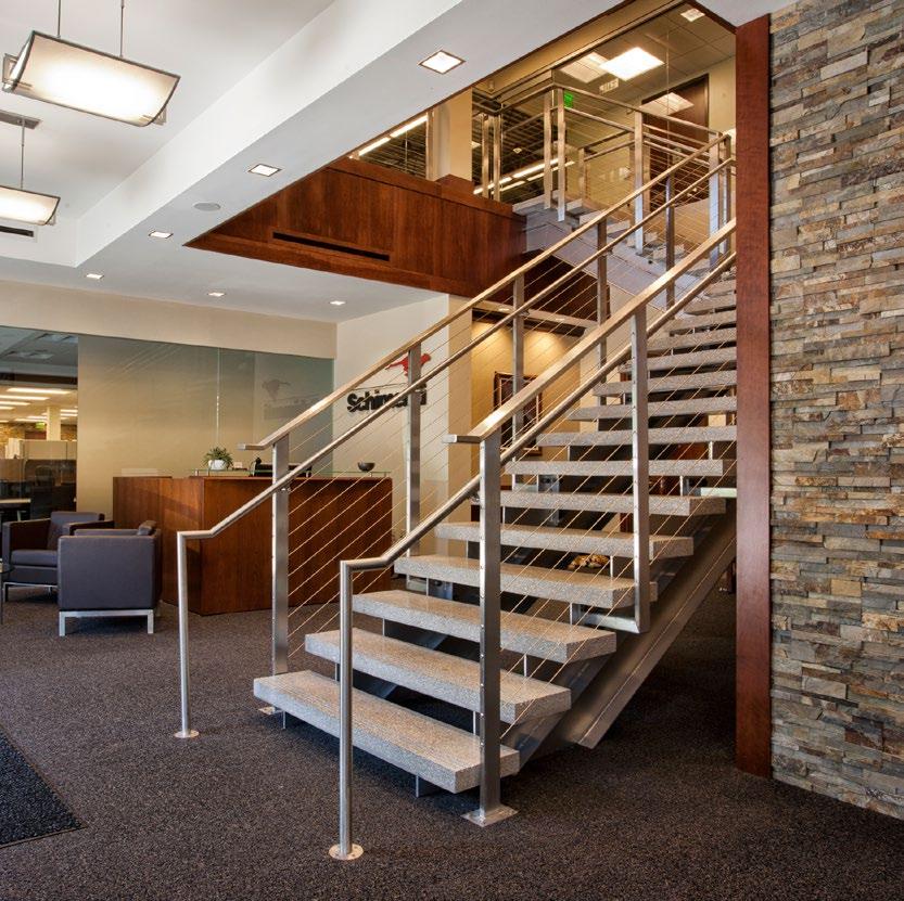 spacious Schimenti Renovation Floating granite steps with metal handrail staircase connect two floors in a contemporary 11,000 square foot