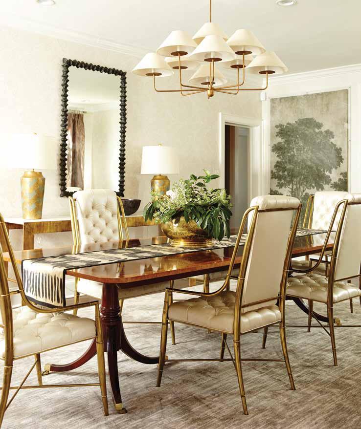 A transitional mid-century modern chandelier by Neirmann Weeks lights a traditional Duncan Phyfe table and vintage Mastercraft bamboo brass chairs reupholstered in pearly Spinneybeck leather.