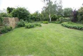 The predominantly southerly facing rear garden has large decking area abutting the rear elevation and extensive lawned area beyond with mature planted borders,