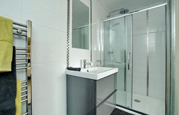 EN SUITE SHOWER ROOM: Contemporary white suite comprising fully tiled shower cubicle with mosaic inset, thermostat controlled drencher shower unit with hand held shower unit, wash hand basin with