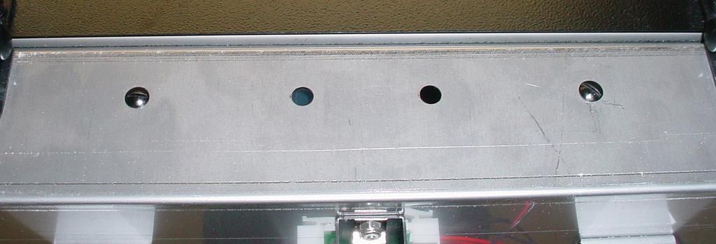 Place a set of key holes in the drip tray bracket over the lower two screws in the panel below the hopper access door; push down gently and