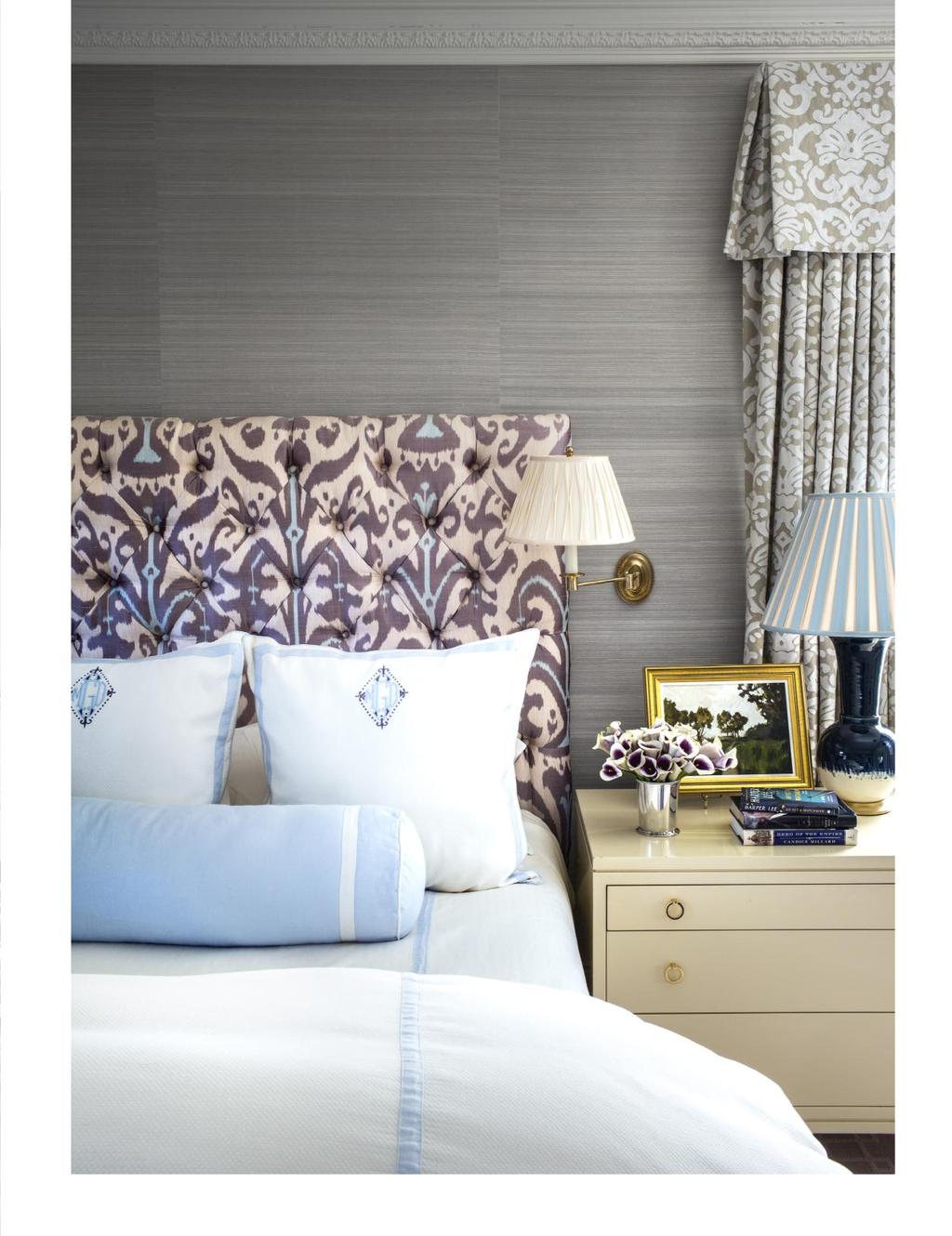 The master bedroom overlooks the woods. To warm it up, I wrapped the walls in a mushroom silk and covered the bed in a large-scale ikat in purple and pale blue.