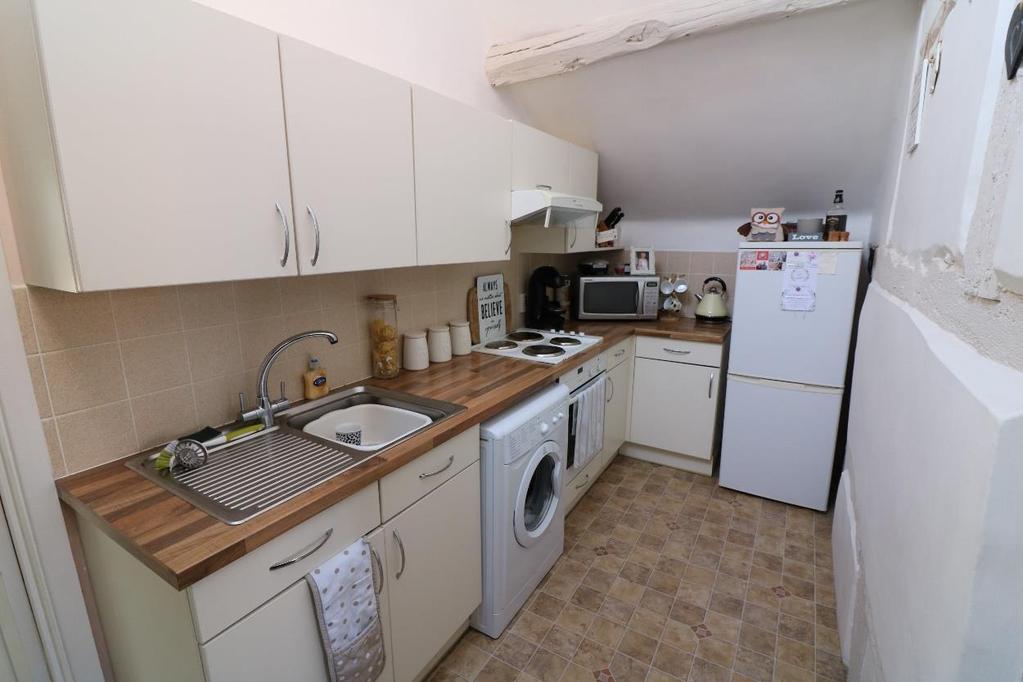 Kitchen Bedroom One measuring approximately 19 x 8 (5.79 x 2.44m) with night storage heater.