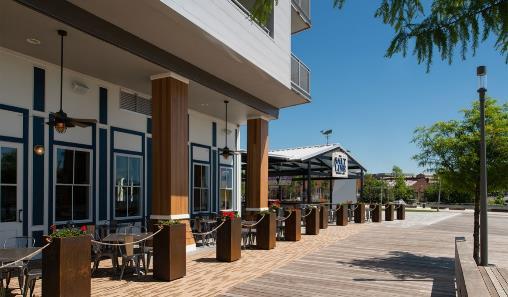 The canopy proposed is a flat roof to provide shade and coverage over the fixed bar area, however it still leaves most of the outdoor seating as open-air.